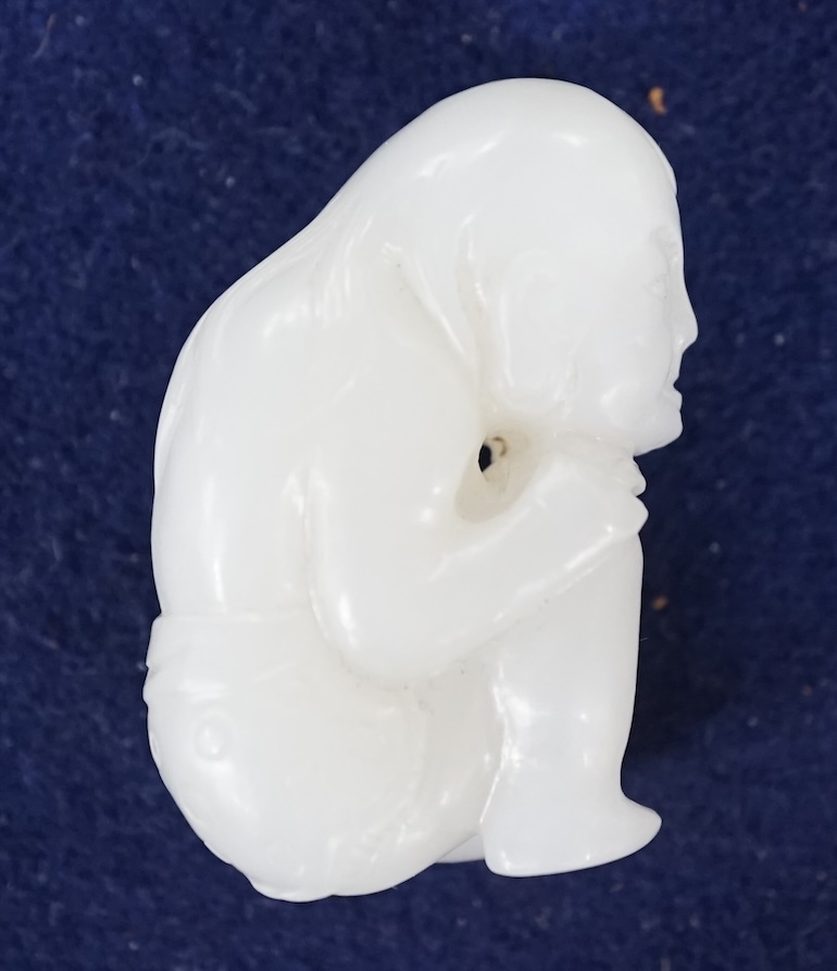 A Chinese white jade carving of a crouching figure, 4.5cm high. Condition - good